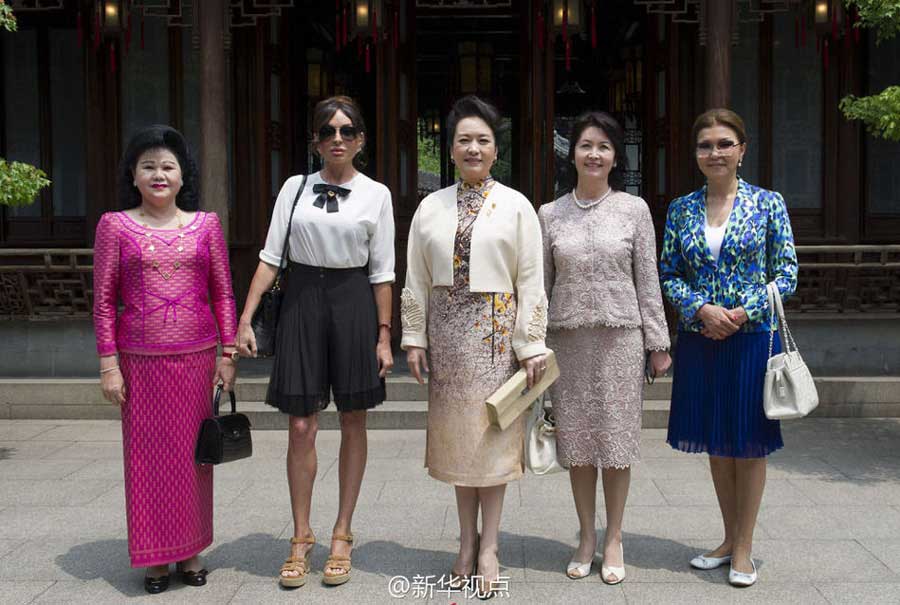 Peng Liyuan(C), wife of Chinese President Xi Jinping and her counterparters pose for a photo as they visit the Yuyuan Garden in Shanghai. Chinese first lady Peng Liyuan invited her counterparts to enjoy China's traditional arts and culture in the centuries-old Yuyuan Garden on Wednesday.[Photo/Xinhua]