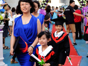 Kindergarten children walk red carpet at graduation ceremony in Qingdao