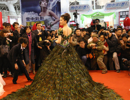  a wedding dress decorated with peacock feathers at the wedding expo held 