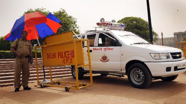 A policeman stands guard under an umbrella in New Delhi, capital of India, on April 19, 2010. Heat waves hit New Delhi since April and the high temperature