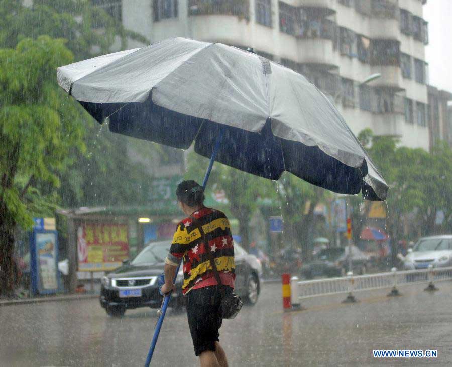 A citizen walks against the heavy rain under a folding umbrella in a street of Qionghai City, south China's Hainan Province, Nov. 6, 2012. Rainy weather appeared in some places of Qionghai City on Tuesday. (Xinhua/Meng Zhongde) 