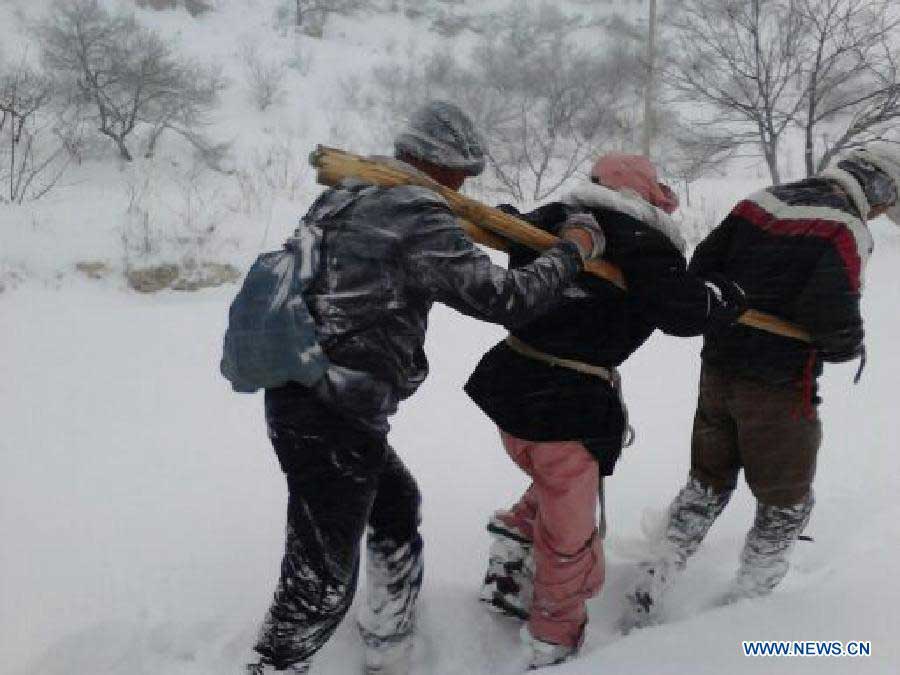 Photo taken by a mobile phone shows a Japanese tourist (C) being saved from a snowstorm in north China's Hebei Province, Nov. 4, 2012. Four Japanese tourists, accompanied by a Chinese tour guide, became trapped by a snowstorm on a snow-covered mountain in Hebei on Nov. 3. Three Japanese tourists who went missing have been confirmed dead, local authorities said Monday. (Xinhua) 
