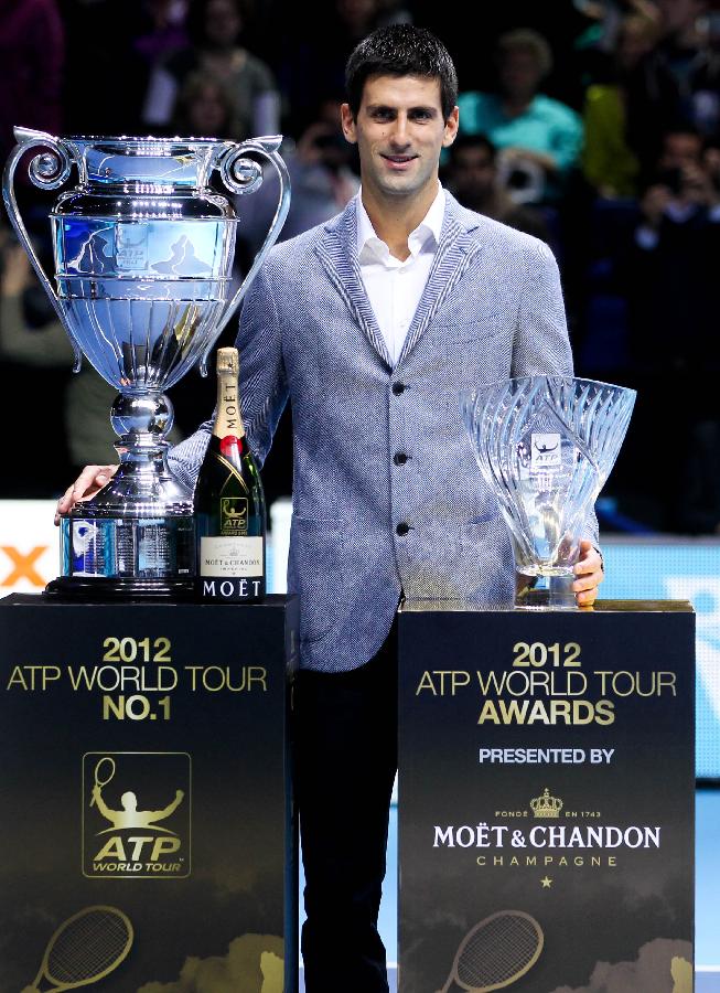 Novak Djokovic of Serbia stands with the trophies of the 2012 ATP World Tour No. 1 Award (L) and the Arthur Ashe Humanitarian Award at the O2 Arena in London, Britain, on Nov. 6, 2012. Djokovic was presented the 2012 ATP World Tour No. 1 Award and the Arthur Ashe Humanitarian Award in London Tuesday. (Xinhua/Tang Shi)