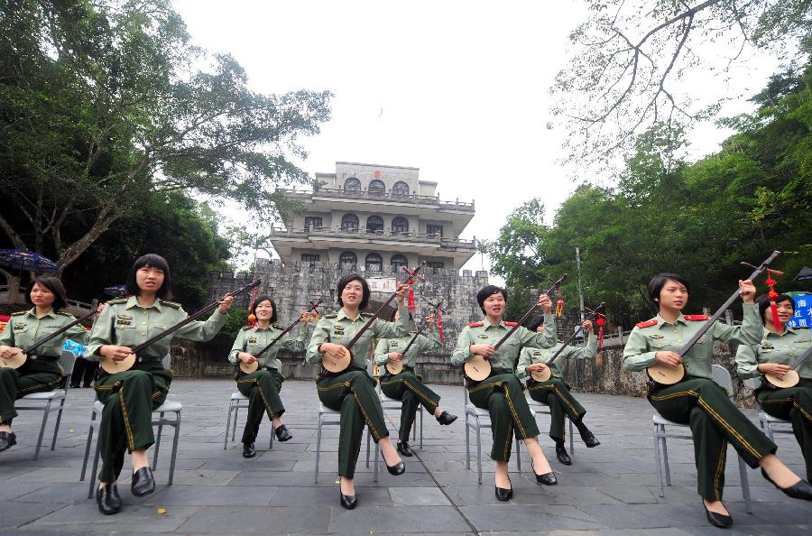 Female soldiers play Tianqin, a traditional musical instrument of Zhuang ethnic group, to celebrate the opening of the 18th National Congress of the Communist Party of China (CPC), in Pingxiang of south China's Guangxi Zhuang Autonomous Region, Nov. 8, 2012. The 18th CPC National Congress was opened in Beijing on Thursday. (Xinhua/Huang Xiaobang)