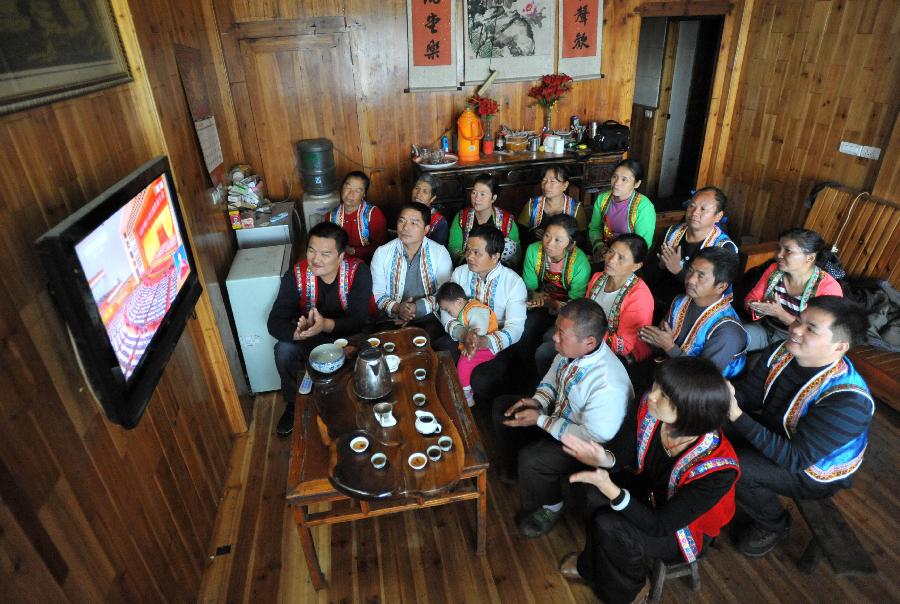 Local villagers watch TV reporting the opening ceremony of the 18th National Congress of the Communist Party of China (CPC) in Nanjiang village of south China's Guangxi Zhuang Autonomous Region, Nov. 8, 2012. The 18th CPC National Congress was opened in Beijing on Thursday. (Xinhua/Lu Boan)