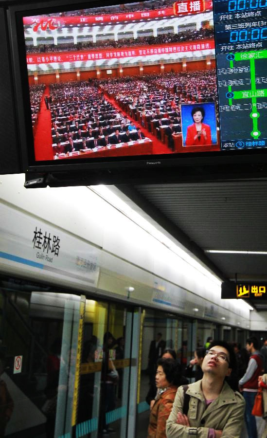 A subway passenger watches TV reporting the opening ceremony of the 18th National Congress of the Communist Party of China (CPC) in east China's Shanghai, Nov. 8, 2012. The 18th CPC National Congress was opened in Beijing on Thursday. (Xinhua/Pei Xin)