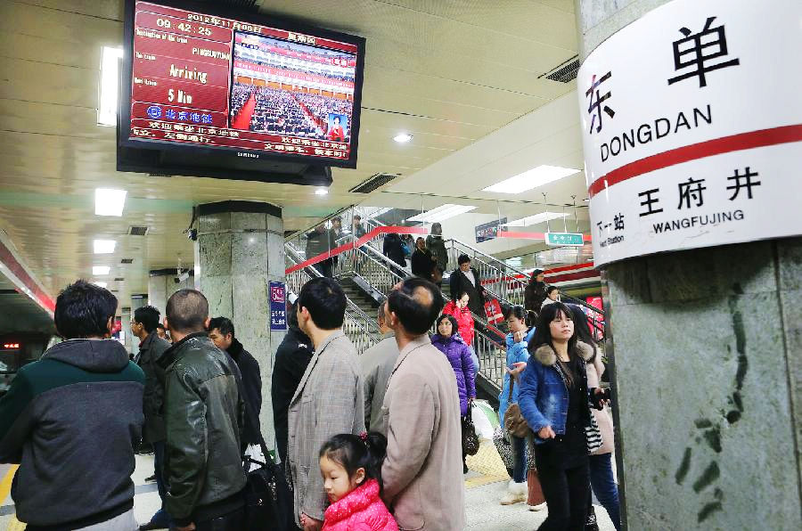 Subway passengers watch TV reporting the opening ceremony of the 18th National Congress of the Communist Party of China (CPC) in Beijing, capital of China, Nov. 8, 2012. The 18th CPC National Congress was opened in Beijing on Thursday. (Xinhua/Wan Xiang)