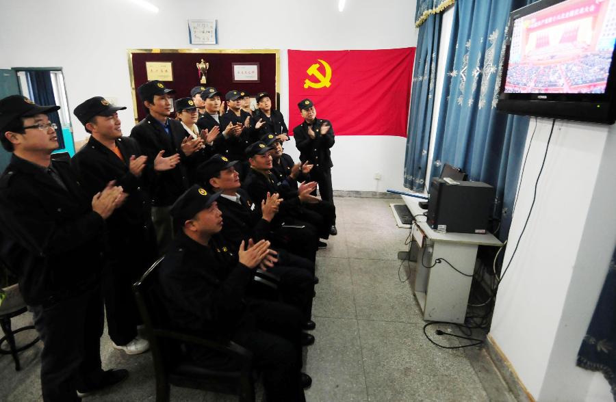 Railway staff members watch live TV report on the opening ceremony of the 18th National Congress of the Communist Party of China (CPC) in Nanchang, capital of east China's Jiangxi Province, Nov. 8, 2012. The 18th CPC National Congress was opened in Beijing on Thursday. (Xinhua/Hu Guolin)