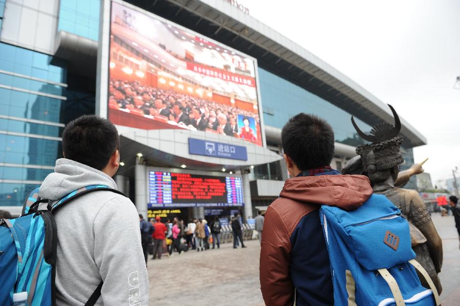Passengers watch TV reporting the opening ceremony of the 18th National Congress of the Communist Party of China (CPC) at the railway station in Guiyang, capital of southwest China's Guizhou province, Nov. 8, 2012. The 18th CPC National Congress was opened in Beijing on Thursday. (Xinhua/Liu Xu)