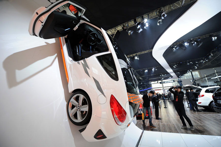 A visitor looks at a car displayed at the 13th International Automobile Industry Exhibition in Hangzhou, capital of east China's Zhejiang Province, Nov. 7, 2012. The five-day exhibition, which kicked off on Wednesday, displays more than 100 vehicles of 60 brands from both home and abroad. (Xinhua/Long Wei) 