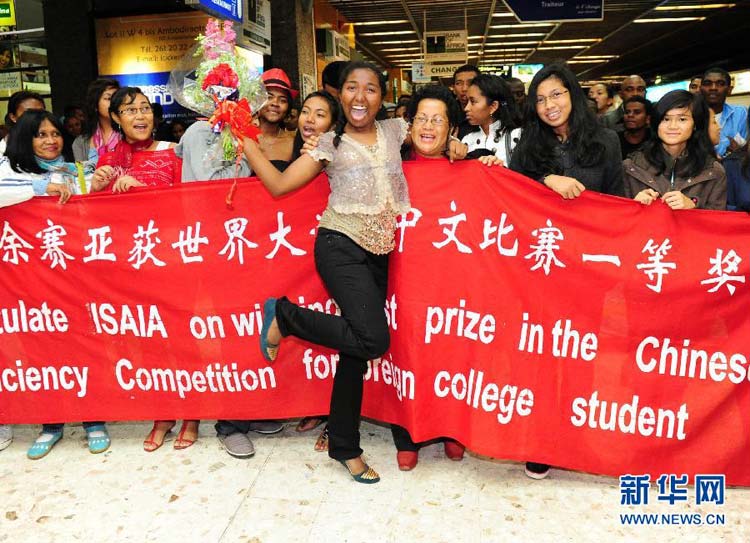 Isaia Herimialy Ratsizakaina (C), who was awarded the first prize during the 11th Chinese Bridge, Chinese Proficiency Competition for Foreign College Students, is greeted upon arrival at the Tananarive airport, Madagascar, July 28, 2012. (Xinhua/Ding Haitao) 