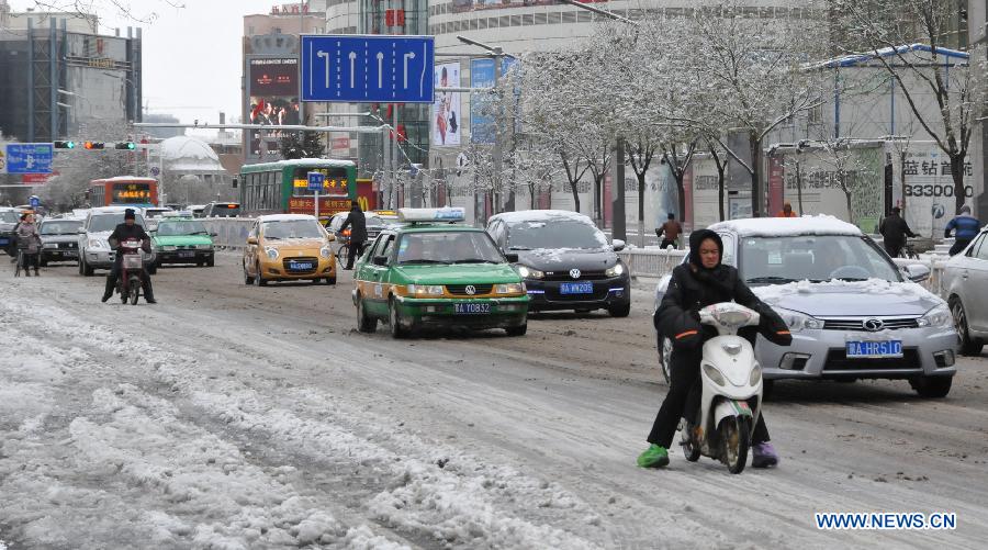 Vehicles run on a snow-covered road in Hohhot, capital of north China's Inner Mongolia Autonomous Region, Nov. 10, 2012. A heavy snowfall hit Hohhot on Nov. 9. (Xinhua/Liu Yide) 