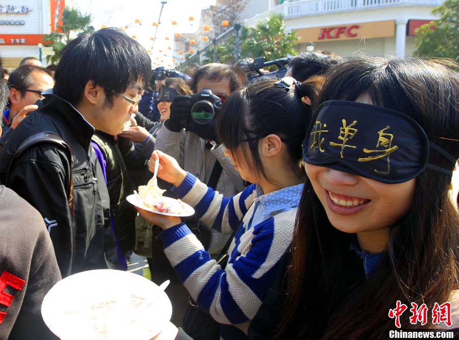 The photo shows a single girl with her eyes covered feeding cake to a boy in Shanghai on Nov. 10, 2012. The interactive episode became the most joyful one during the activity of Single's Day which was held in Shanghai Happy Valley in Shanghai on Nov. 10, 2012. (Chinanews.com/Pan Feisuo) 