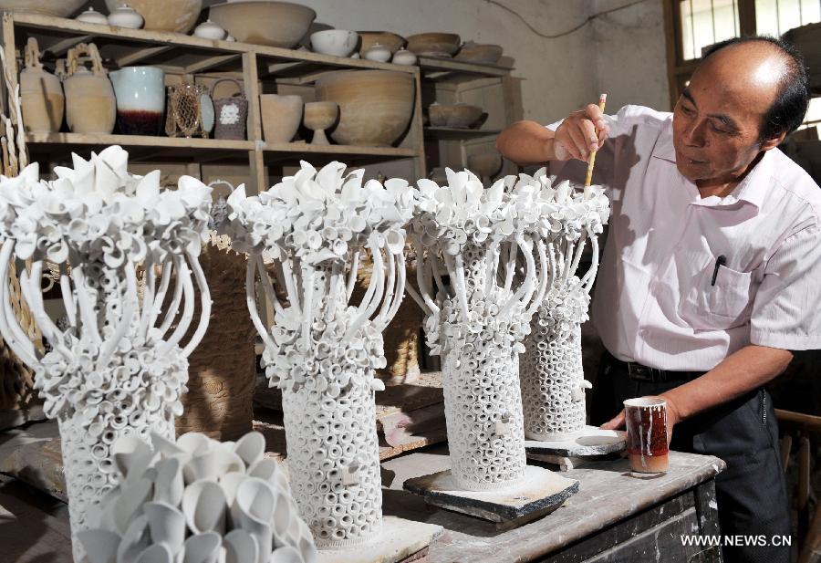 Ceramic artist Ren Ruihua works at his studio in Jingdezhen, east China's Jiangxi Province, July 12, 2012. (Xinhua/Song Zhenping) 