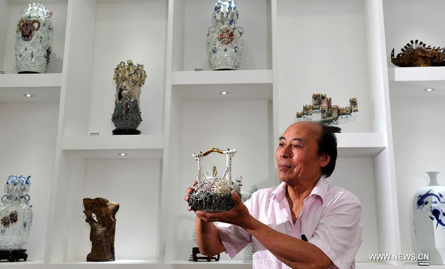 Ceramic artist Ren Ruihua introduces his works at his studio in Jingdezhen, east China's Jiangxi Province, July 12, 2012. (Xinhua/Song Zhenping) 