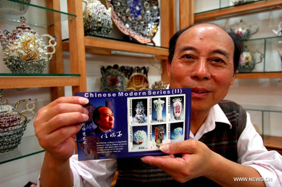 File photo taken on May 15, 2007 shows the ceramic artist Ren Ruihua presents a stamp sheet of his porcelain works at his studio in Jingdezhen, east China's Jiangxi Province. Ren Ruihua is a pioneer of modern porcelain in China.  (Xinhua/Song Zhenping) 