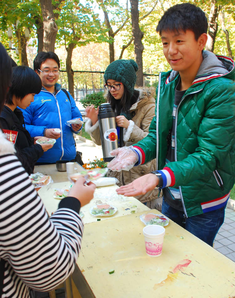 A student distributes samples of Gernan food to visitors.(People's Daily Online/Gao Yinan) 