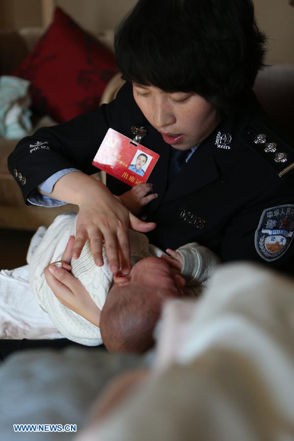 Jiang Min, a delegate to the 18th National Congress of the Communist Party of China (CPC), puts ointment on the face of her son, who had eczema, in Beijing, capital of China, Nov. 13, 2012.(Xinhua/Jin Liwang)