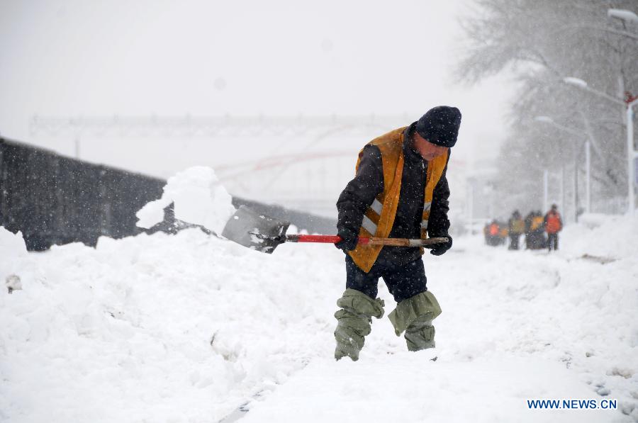 A working staff cleans snow piled aside tracks at the Hegang Railway Station in Hegang, northeast China's Heilongjiang Province, Nov. 13, 2012. Heavy snowstorms swept northeastern regions of Heilongjiang since last Sunday, forcing highways to close. Local authority of railway service initiated an emergency plan to maintain order of stranded passengers. (Xinhua/Wang Kai) 