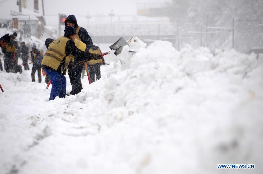 Working staff clean snow piled aside tracks at the Hegang Railway Station in Hegang, northeast China's Heilongjiang Province, Nov. 13, 2012. Heavy snowstorms swept northeastern regions of Heilongjiang since last Sunday, forcing highways to close. Local authority of railway service initiated an emergency plan to maintain order of stranded passengers. (Xinhua/Wang Kai) 