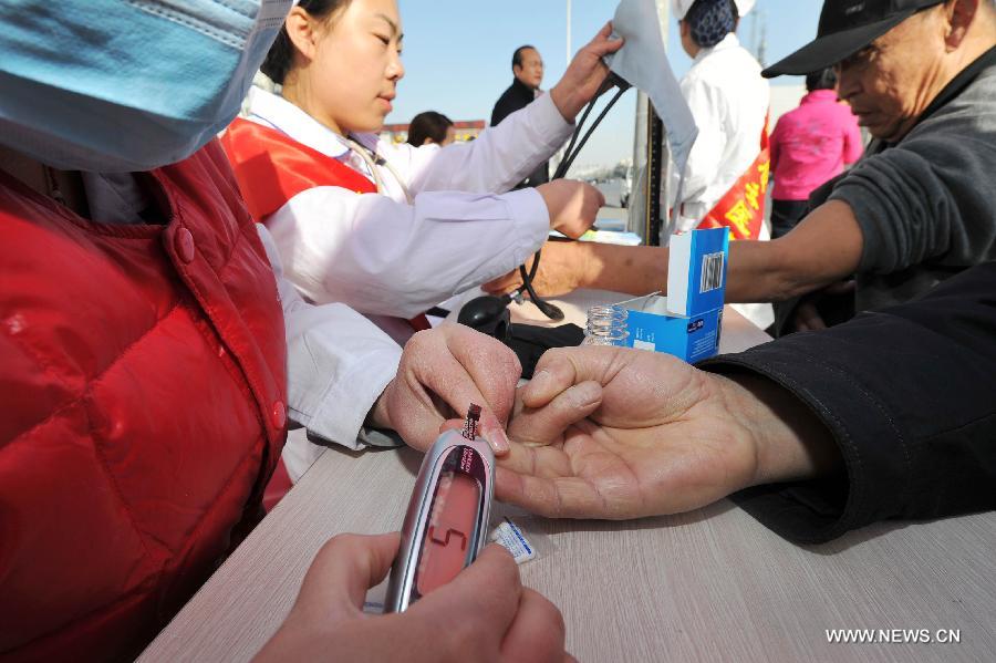 A nurse checks the blood glucose for a citizen during a free clinic service in Yinchuan,capital of northwest China's Ningxia Hui Autonomous Region, Nov. 14, 2012. An activity of free clinic service was held by Ningxia Chinese Medicine Hospital to welcome the World Diabetes Day on Wednesday. (Xinhua/Peng Zhaozhi)  