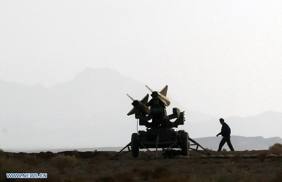 An Iranian army member is seen beside a surface-to-air missile during a military drill at an undisclosed location in Iran, on Nov. 14, 2012. Iran's Army and the Islamic Revolution Guards Corps have test-fired a range of missiles and unveiled their military achievements in the ongoing joint air defense drill starting on Monday. (Xinhua/Majid Asgaripour)