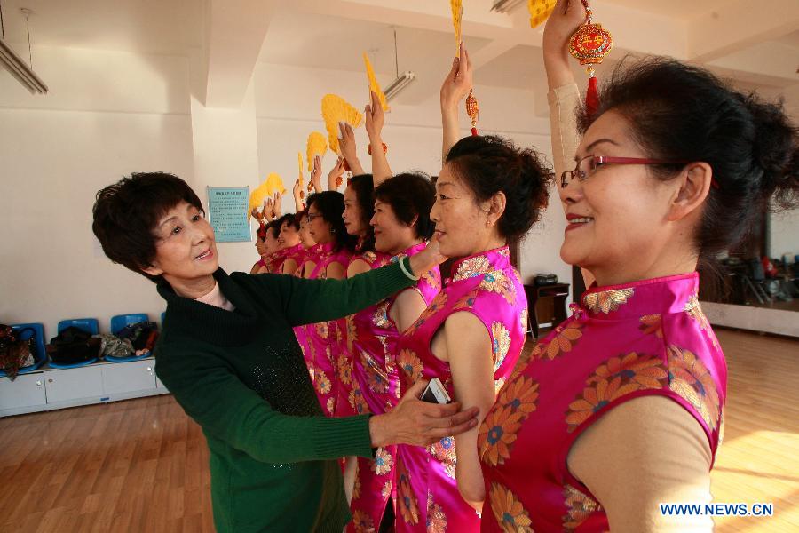 72-year-old Li Ling (L), leader of an elder model team, instructs her teammates' performance in Lanzhou, capital of northwest China's Gansu Province, Nov. 14, 2012. The elder model team that has 26 models with an average age of 62 is preparing for Gansu's 6th Elder Model Pageant that is to be held on Saturday. (Xinhua/Lu Yang) 