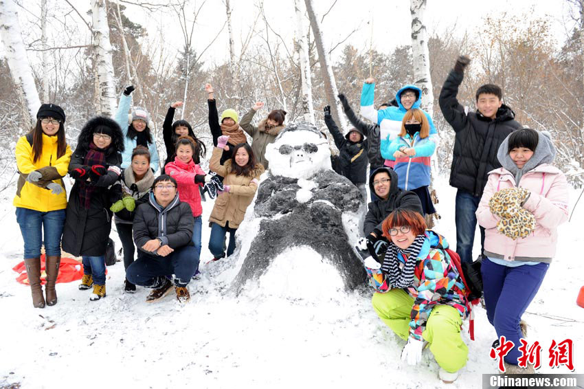 People dance ‘Gangnam style’ in front of a snowman that looks like “Psy” in Changchun on Nov.14 2012. The snow brought a lot of fun for residents in Changchun. (Chinanews/Zhangyao)