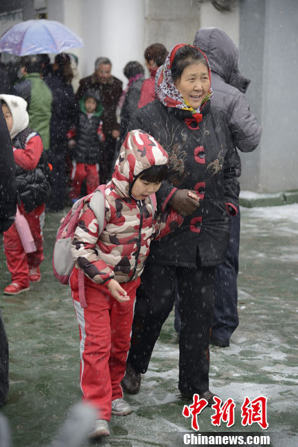 Pictures shows parents picking up children after school in snow in Hohhot on Nov. 15, 2012.(Chinanews/Liu Wenhua)