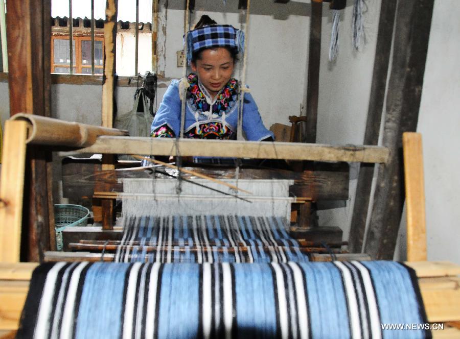 A woman of Buyi ethnic group weave cloth at Wangmo County in Qianxinan Buyi and Miao Autonomous Prefecture, southwest China's Guizhou Province, Nov. 16, 2012. Weaving cloth plays an important role in the development of local economy. (Xinhua/Shi Xinrong)