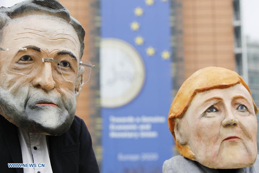 Activists wearing giant heads of German Chancellor Angela Merkel and Spanish Prime Minister Mariano Rajoy (R) attend a rally in front of EU headquarters in Brussels, Belgium, Nov. 19, 2012. Demonstrators installed the giant flag to urge EU backing the Palestinian membership in the United Nations. (Xinhua/Zhou Lei) 