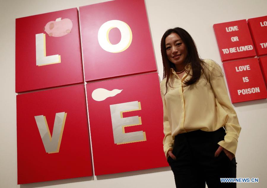 Ai Jing stands in front of her creation at the art exhibition "I Love Aijing" in the National Museum of China in Beijing, China, Nov. 19, 2012. The art exhibition, showcasing Ai Jing's creations, kicked off here Monday. Ai Jing, a pop singer who won her fame in 1990s, has been involved in artwork exhibition since 2007, showing her work in Beijing, Shanghai and New York. (Xinhua/Ren Zhenglai) 