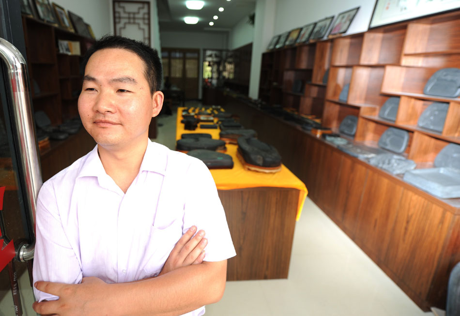 Wen Xin stays in his inkstone carving showroom in Shexian County of east China's Anhui Province, Aug. 7, 2012. (Xinhua/Du Yu)