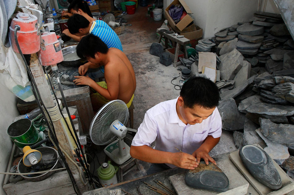 Wen Xin (front) and his apprentices work in their studio in Shexian County of east China's Anhui Province, Aug. 7, 2012. (Xinhua/Xu Zijian)