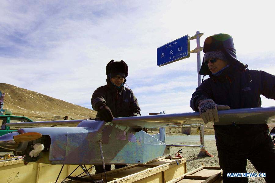 Technicists from the Shandong Electric Power Research Institute (SEPRI) examine an unmanned aircraft which is designed to inspect power transportation lines in regions of high altitude, during a test in Qinghai, a province on the Qinghai-Tibet Plateau, northwest China, Nov. 21, 2012. A research team of the SEPRI has recently conducted a flight test of unmanned aircrafts over the ground with altitude of 4,500 meters, which marks the end of the first round of the unmanned aircraft test project for inspecting power transportation lines on plateaus. (Xinhua)