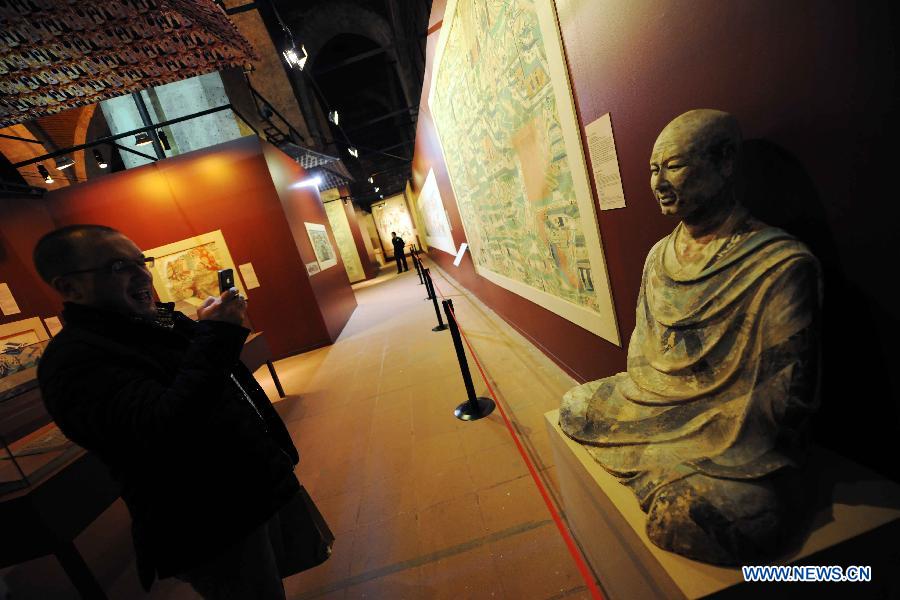 A visitor watches the duplicate of a statue at "The Colors of Dunhuang: A Magic Gateway to the Silk Road" exhibition held in Mimar Sinan University in Istanbul of Turkey, on Nov. 20, 2012. The Exhibition kicked off here on Tuesday. (Xinhua/Ma Yan)