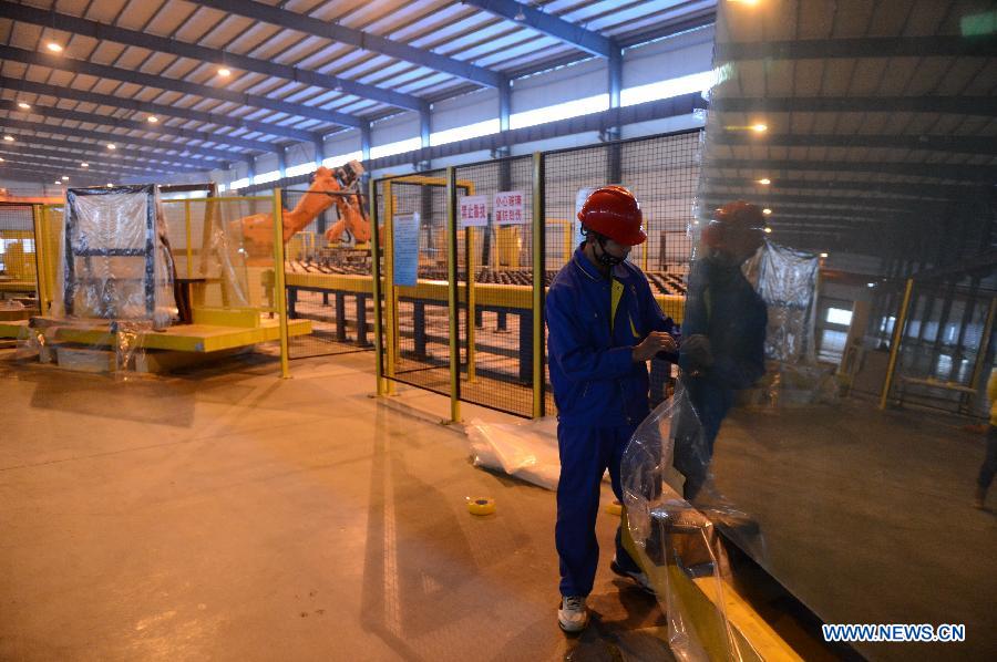 A man works on the production line in Hongyu energy company in Zhangshu, east China's Jiangxi Province, Nov. 22, 2012. The company has invested 350 million yuan (56.1 million dollars) and built the largest energy efficiency glass production line in China. (Xinhua/Zhou Mi)