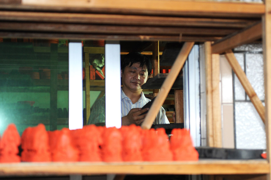 Xiang Shengli chooses suitable mold to shape inksticks in Shexian County of east China's Anhui Province, Aug. 11, 2012. (Xinhua/Du Yu)