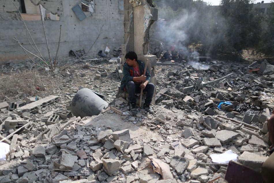 A Palestinian sits amid the ruins of a refugee camp in northern Gaza City, on Nov. 17, 2012. (Photo/Xinhua)