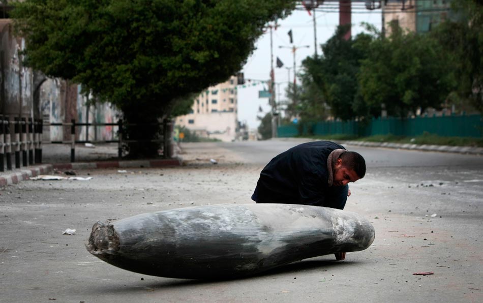 A Palestinian policeman examines an Israeli bomb in a street of Gaza City, on Nov. 17, 2012. (Xinhua/AFP)