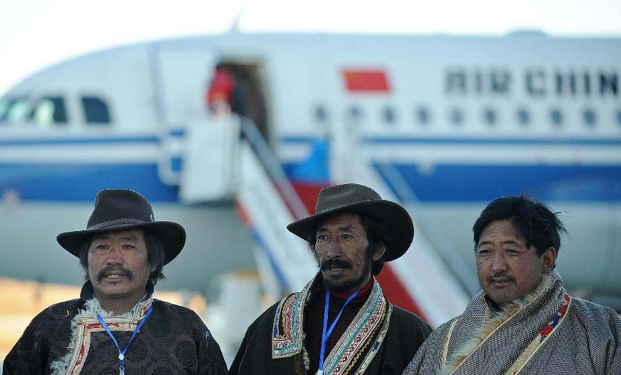 Staff members pose for group photos in front of the test flight at the Daochengyading Airport in Daocheng County of the Tibetan Autonomous Prefecture of Garze, southwest China's Sichuan Province, Nov. 23, 2012. The first test flight of the airport successfully landed Friday. With the height of 4,411 meters above sea level, the Daochengyading Airport becomes the highest civil airport in the world. (Xinhua/Xue Yubin) 