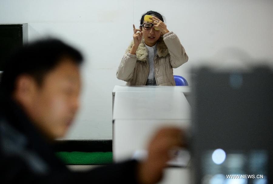 A candidate takes vision test at a job interview for airline stewards in Lanzhou, capital of northwest China's Gansu Province, Nov. 24, 2012. The Gansu branch of China Eastern Airline launched a job interview to recruit airline stewards on Saturday, attracting more than 300 applicants.(Xinhua/Zhang Meng) 
