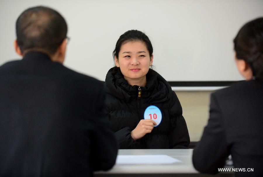 A candidate receives a job interview for airline stewards in Lanzhou, capital of northwest China's Gansu Province, Nov. 24, 2012. The Gansu branch of China Eastern Airline launched a job interview to recruit airline stewards on Saturday, attracting more than 300 applicants.(Xinhua/Zhang Meng) 