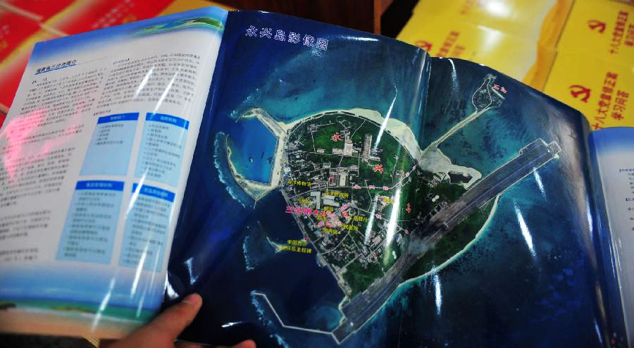 A citizen looks through the map of Sansha city at Xidan Books Building in Beijing, capital of China, Nov. 24, 2012. The first official map of the newly-established Sansha city in south China's Hainan Province was published on Saturday. (Xinhua/Liu Changlong)