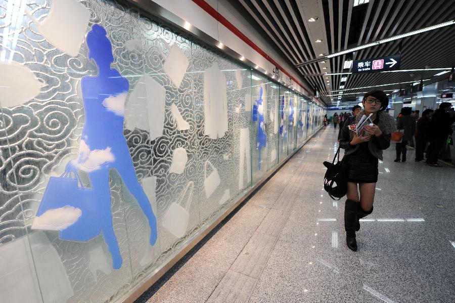 Passengers walk past an art wall inside the Longxiangqiao Station of the Hangzhou Subway Line 1 in Hangzhou, capital of east China's Zhejiang Province, Nov. 24, 2012. Among the 31 stations of the Hangzhou Subway Line 1 which started a trial operation on Saturday, 11 stations were decorated with distinctive art designs. (Xinhua/Ju Huanzong) 