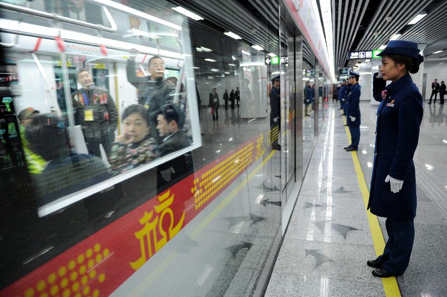 Crew members of Hangzhou Subway Line 1 salute as a subway train leaves the station in Hangzhou, capital of east China's Zhejiang Province, Nov. 24, 2012. Hangzhou Subway Line 1, the first subway in Zhejiang covering a distance of 47.97 kilometers, was put into a trial operation on Saturday after five years of construction. (Xinhua/Ju Huanzong) 