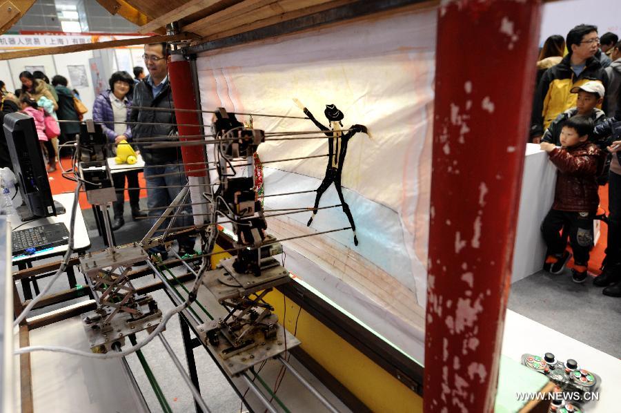 A robot performs shadow play during a robot show held in Qingdao University, Qingdao, east China's Shandong Province, Nov. 25, 2012. The robot show, the first kind of this exhibition in Shandong, showcased the latest achievement of robot-related technology, involving over 100 exhibits from home and abroad. (Xinhua/Li Ziheng) 