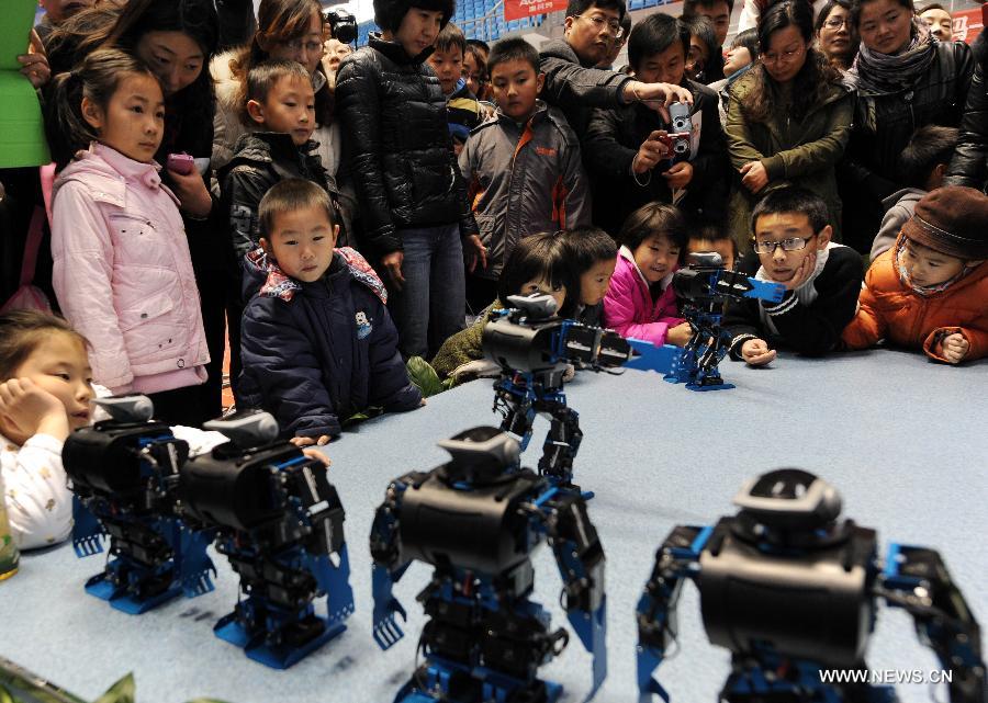 Visitors view robots dancing in a robot show held in Qingdao University, Qingdao, east China's Shandong Province, Nov. 25, 2012. The robot show, the first kind of this exhibition in Shandong, showcased the latest achievement of robot-related technology, involving over 100 exhibits from home and abroad. (Xinhua/Li Ziheng) 