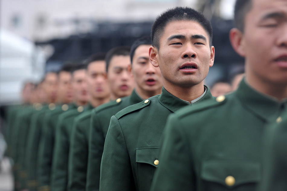 The veterans to be discharged from active duty in the direct detachment of the armed police force in Shanxi chant the national anthem at a farewell meeting on Nov. 25, 2012. Taking off epaulets, badges and collar badges, the veterans waved goodbye to their comrades with the deep attachment to the camp and started to return home. (Xinhua/Zhan Yan)