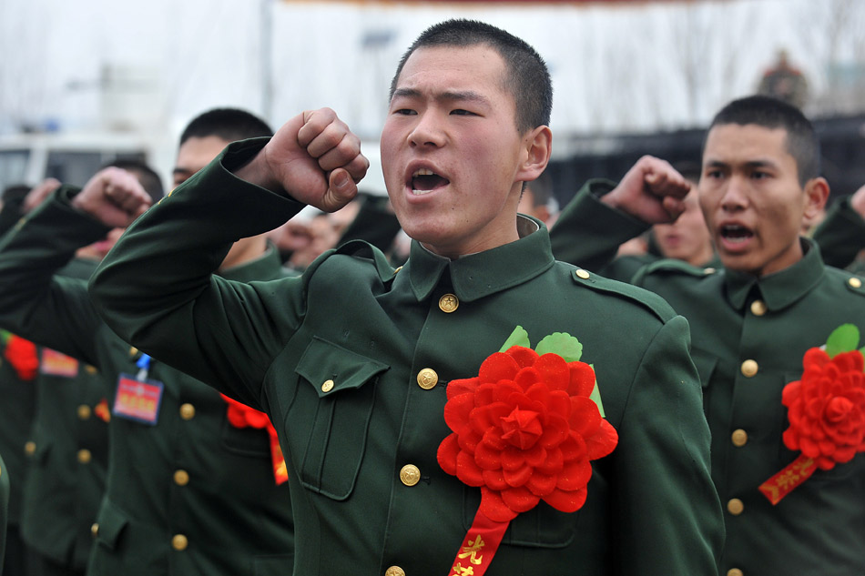 The veterans to be discharged from active duty in the direct detachment of the armed police force in Shanxi take solemn oaths at a farewell meeting on Nov. 25, 2012. Taking off epaulets, badges and collar badges, the veterans waved goodbye to their comrades with the deep attachment to the camp and started to return home. (Xinhua/Zhan Yan)
